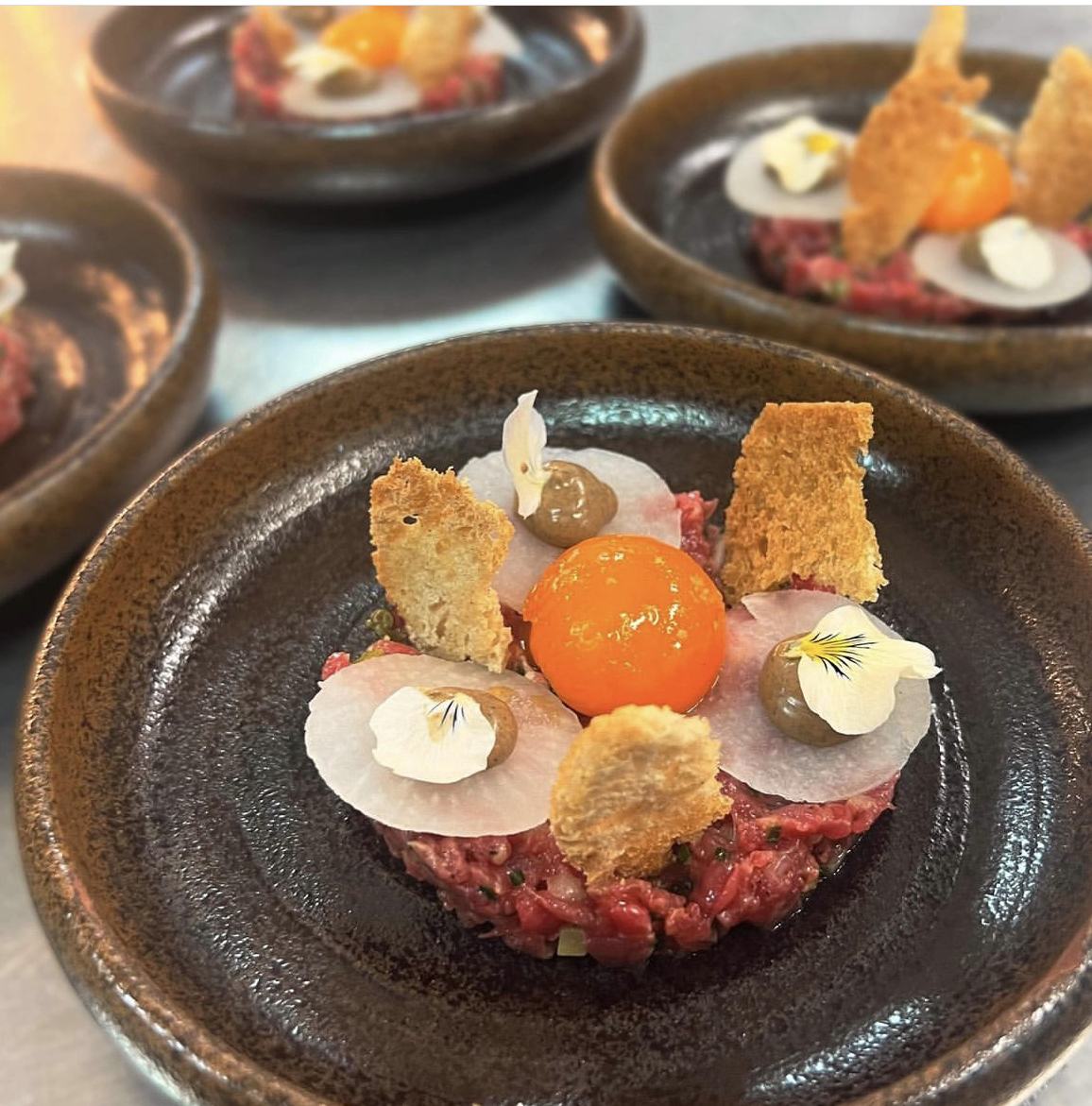 Beef tartare with cured egg yolk, kohlrabi and viola petals